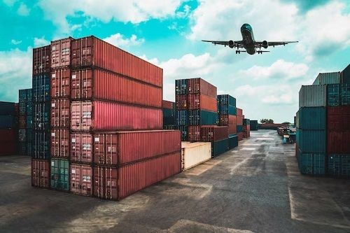 Aircraft departing over a container yard